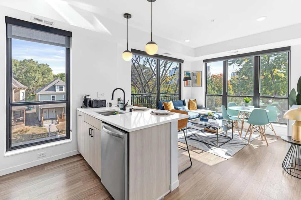 Bright, open layout with modern kitchen, cozy living area, and floor-to-ceiling windows.