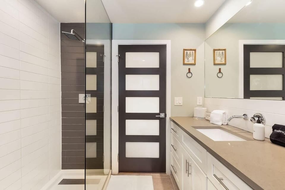 Spacious bathroom with rainfall shower and double vanity. Easy to share and simple to keep clean.