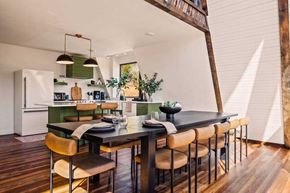 Seats 10+ around a grand dining table with leather chairs, soaring A-frame ceilings, and exposed timber beams — the ultimate setting for milestone celebrations, family reunions, girls' getaways, and group retreats in the Smoky Mountains.