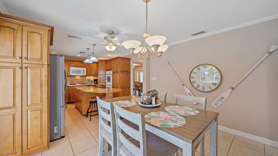 The beautifully decorated casual dining nook provides a seamless transition into the spacious, fully-stocked kitchen, making serving and socializing effortless.