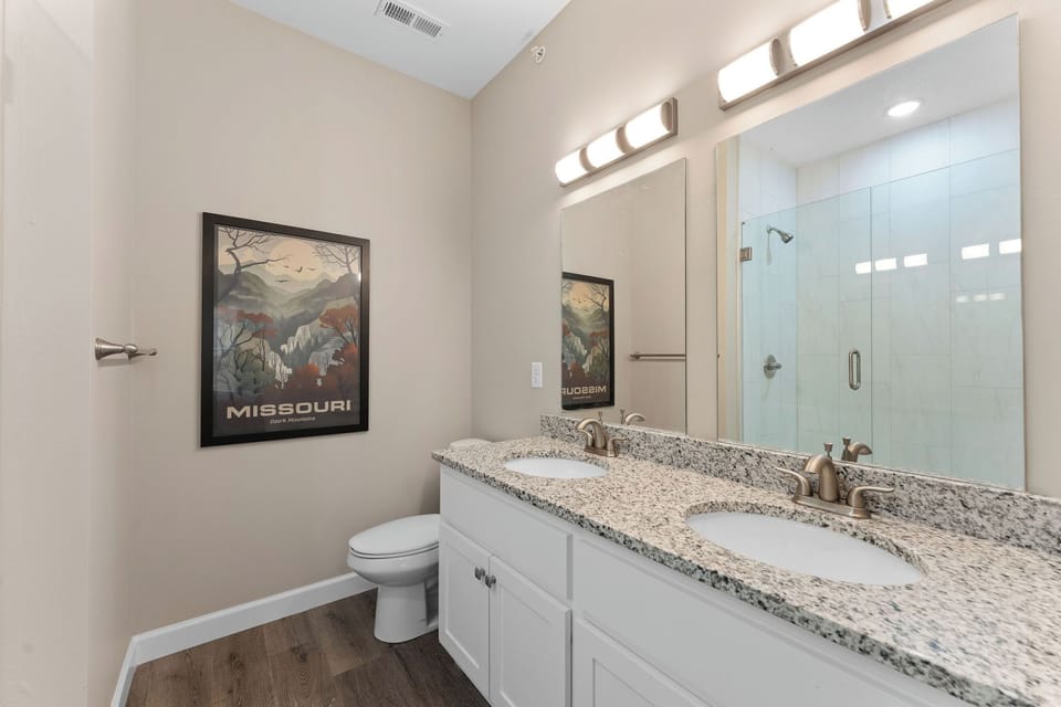 Relax in this master bathroom with double vanity and a charming Missouri print.
