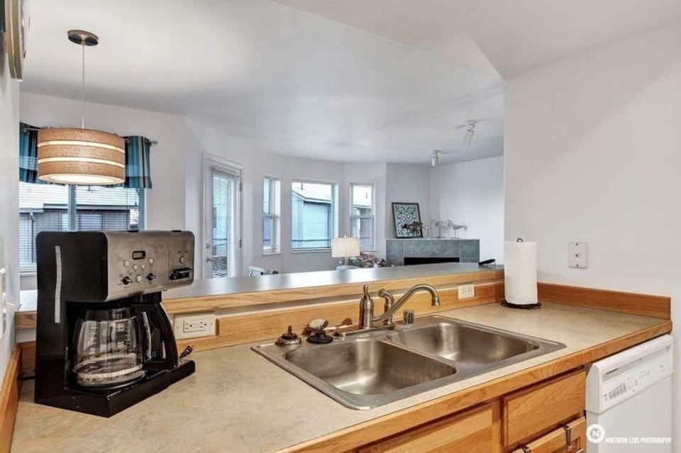 Full kitchen looking out over dining room and living room.  A wall of windows fills the space with light and peaceful views of the Chugach Mountains and Reflection Lake.  A great place for a cup of coffee to start your day!