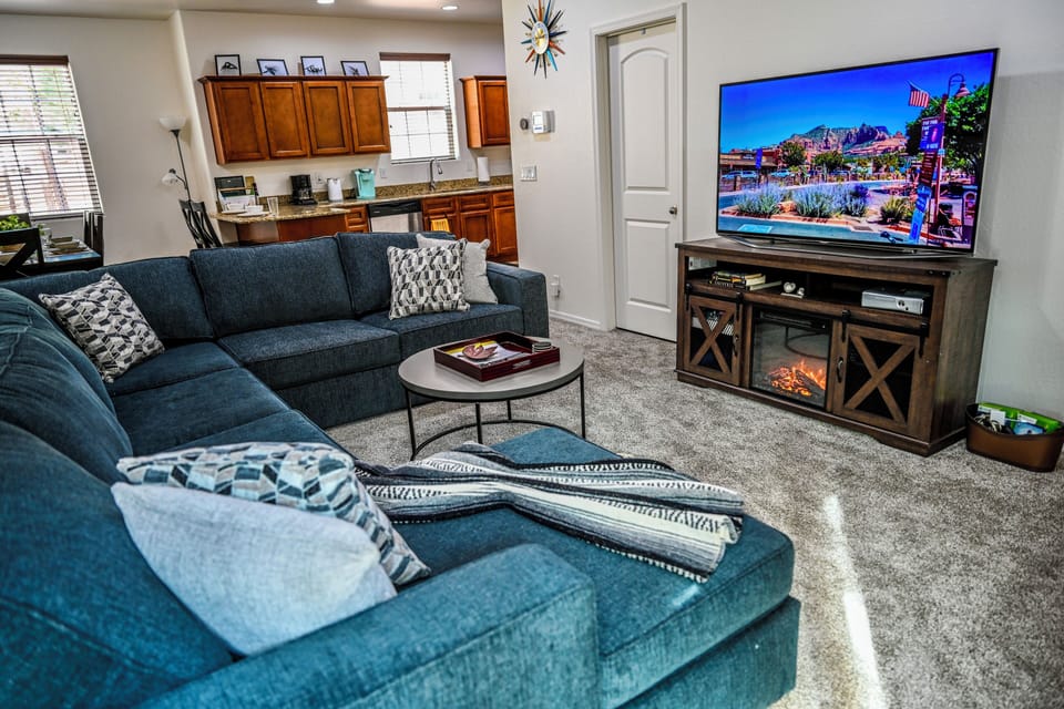Living room with 65 inch smart TV with electric fireplace and XBOX/DVD player.