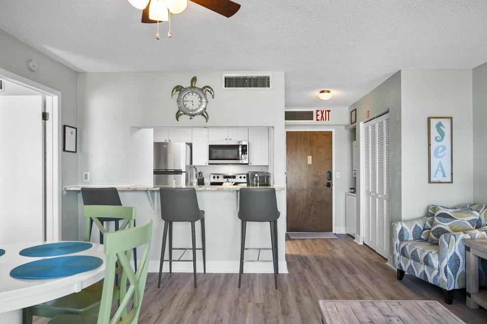 The living room flows seamlessly into the dining space, complete with additional countertop seating, making it perfect for family meals, casual gather