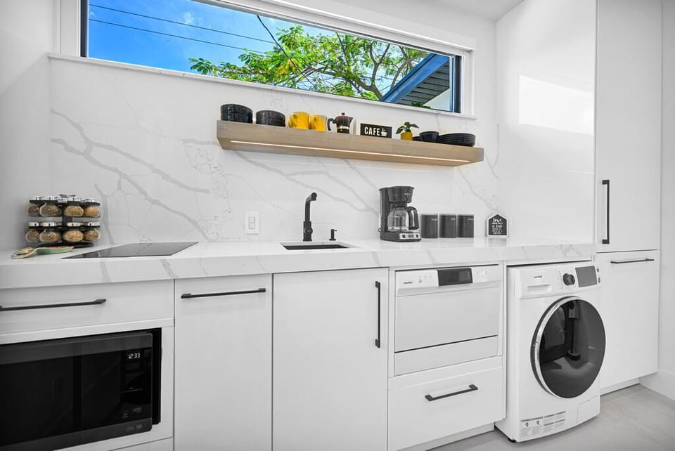 "Bright modern kitchenette with sleek design and outdoor views."