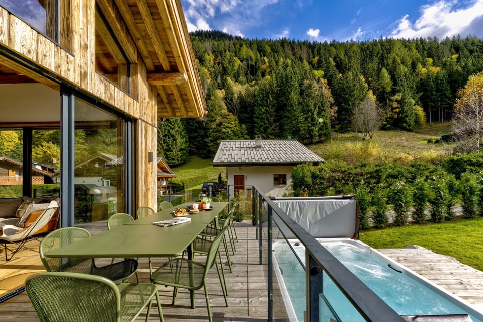 Balcony with dining furniture overlooking large hot tub