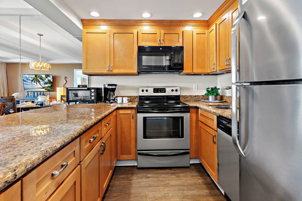 Your gourmet kitchen awaits with rich wood cabinetry, granite counters, and stainless-steel appliances. Perfect for preparing memorable meals together.