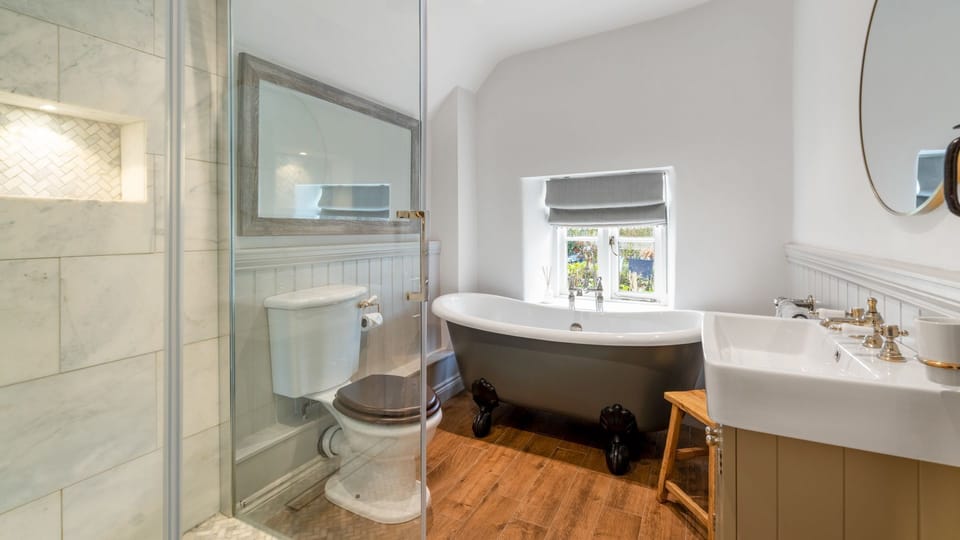 The fabulous bathroom has a splash of luxury with a clawfoot bath