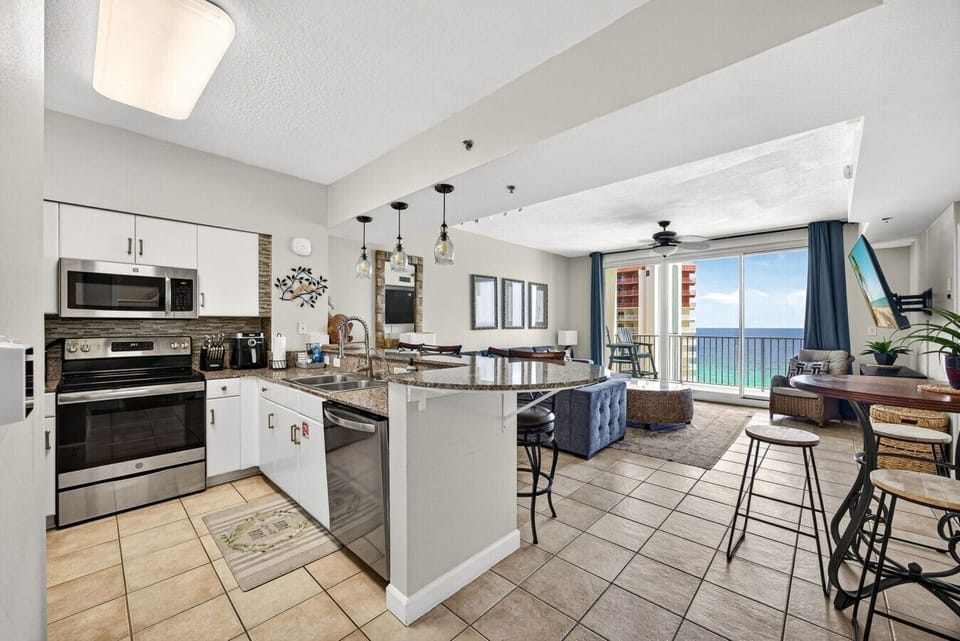 Cook, gather, and dine with ease in the open-concept kitchen and living area featuring granite countertops and Gulf views.
