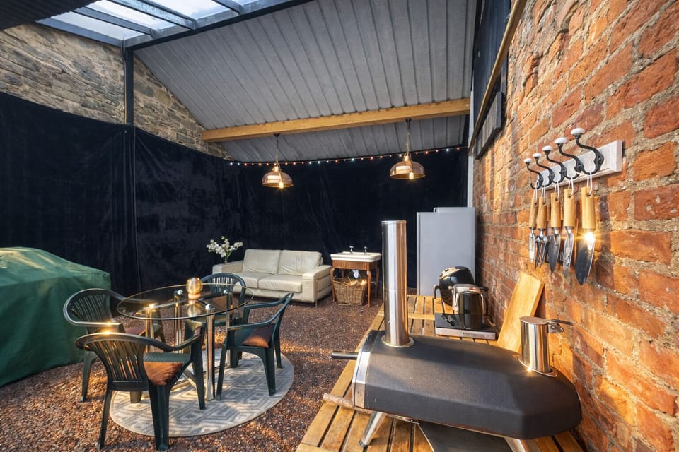 Shared outdoor kitchen with BBQ, dining and cosy seating 