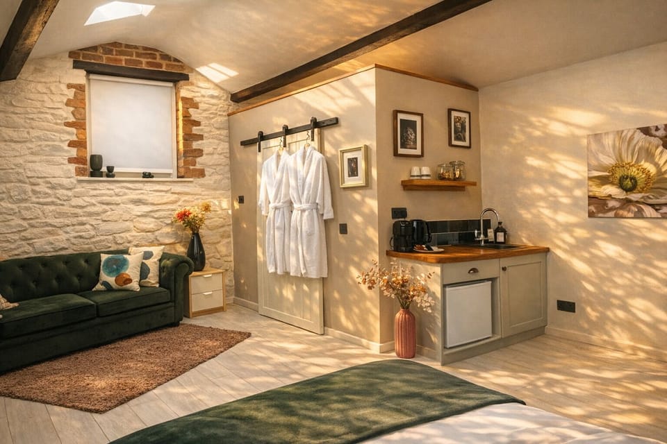 Linden Lodge interior with kitchenette, green sofa bed & robes for the spa.
