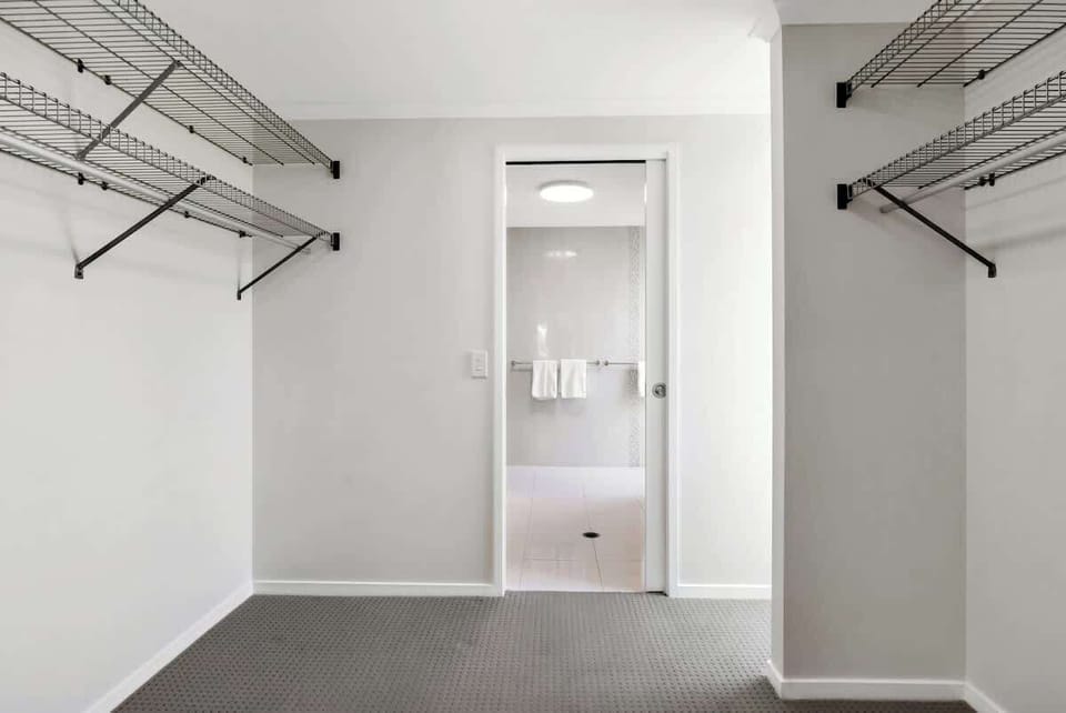 A walk-in wardrobe connects the primary bedroom and ensuite with ample storage space.
