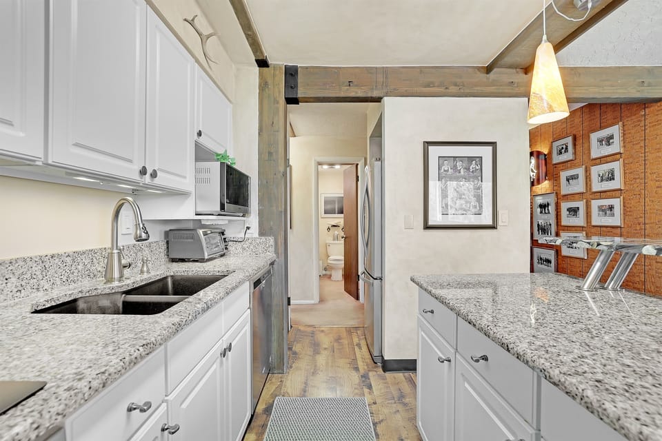 Galley kitchen with fridge, freezer, washer/dryer, and easy access to the main floor bath!