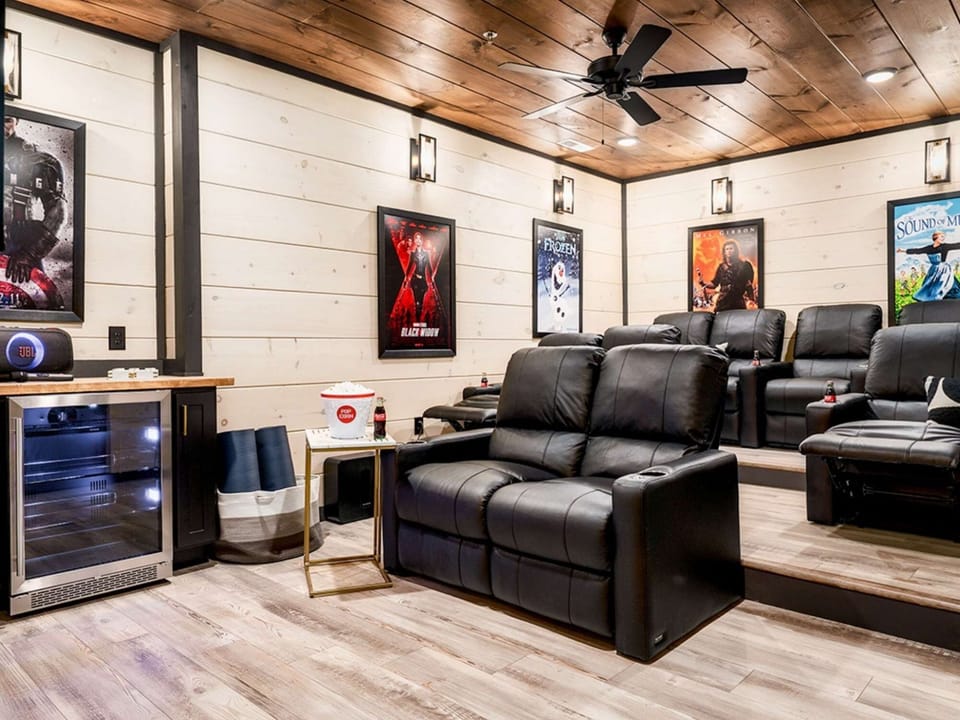 A stylish private theater room with plush seating, microwave and a big-screen TV.