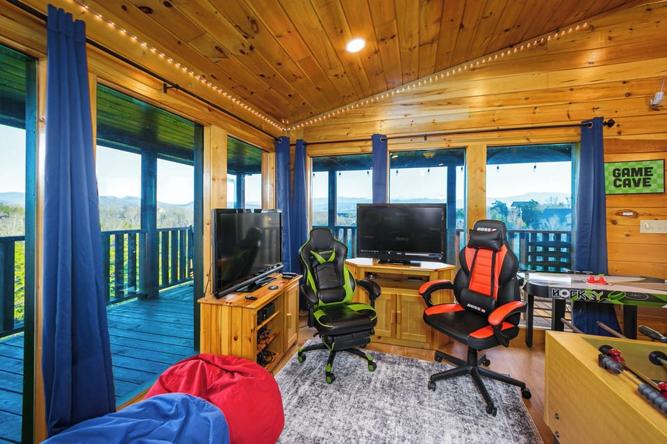 Top floor game area with two TV's, gamer chairs, games, and views