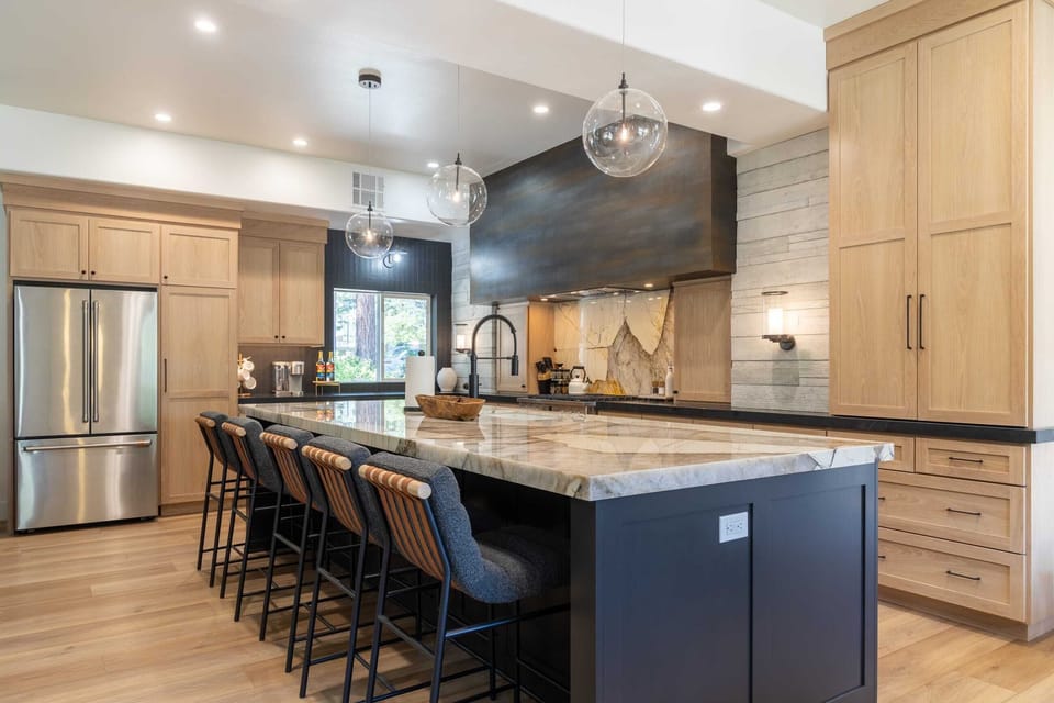 Chef's kitchen with high-end appliances, white oak cabinetry, and Patagonia quartzite marble counters