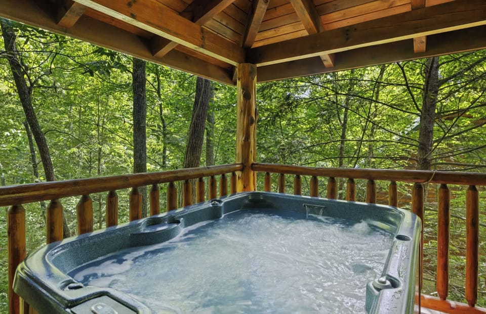 Covered hot tub surrounded by nature with hammocks and outdoor furniture