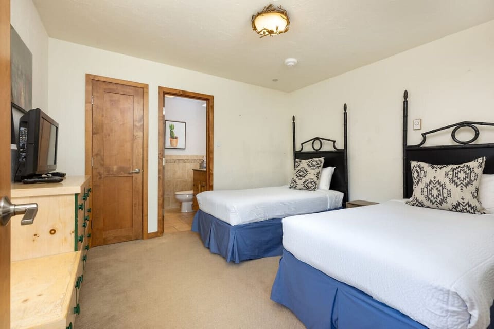The lower floor bedroom with two twin beds, en-suite bathroom and TV