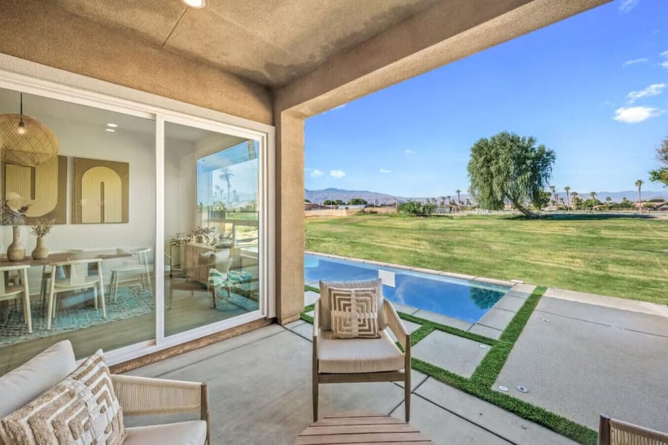 Dine alfresco on the covered patio overlooking the pool & expansive grassy views.