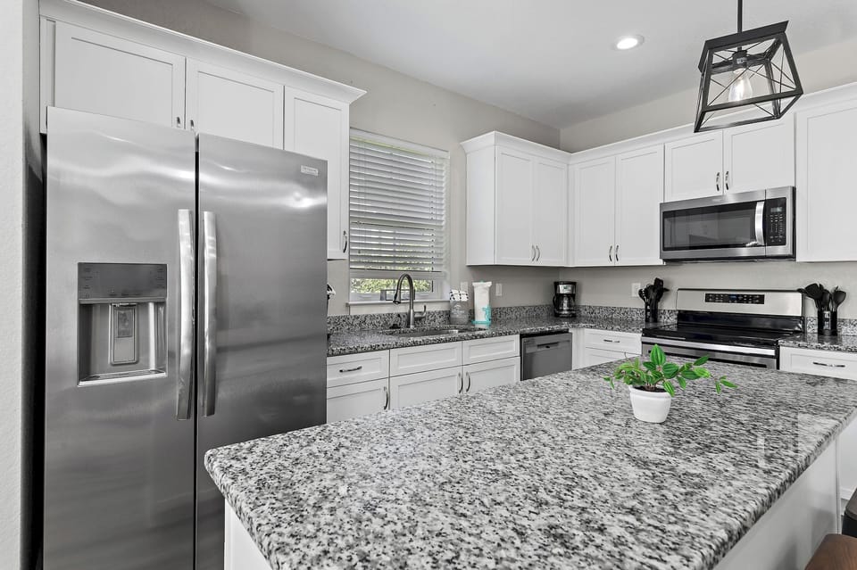 The kitchen is equipped with a large two-door refrigerator with ice maker, stove, oven, coffee-maker and dishwasher.