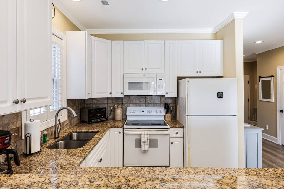 Fully equipped kitchen with spacious countertops, stove, microwave, and oven—perfect for cooking and dining together!