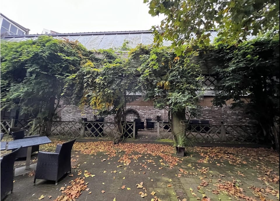 A tranquil patio surrounded by lush foliage, offering comfortable seating and a relaxing atmosphere, ideal for unwinding in nature's embrace.