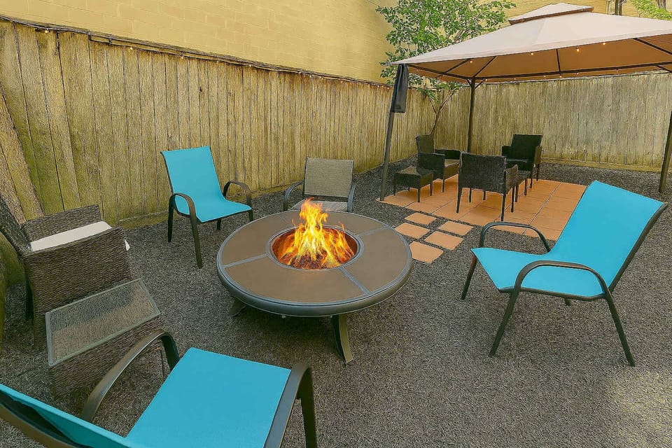 Backyard setup with firepit, chairs, and wooden fence.