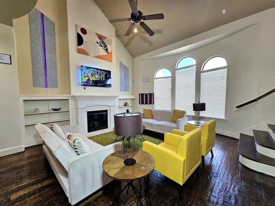 Modern living room with bright lighting and cozy white couches.
