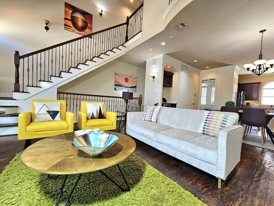Elegant lounge area with green rug and yellow chairs.