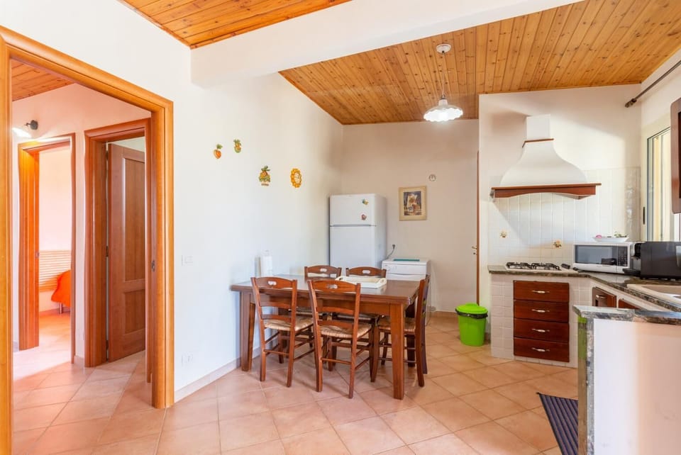 Open-plan living room with sofa, dining area, kitchen, A/C, WiFi internet, satellite TV, and terrace access