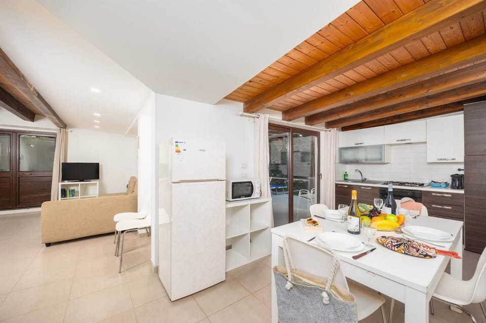Open-plan living room with sofa, dining area, kitchen, A/C, WiFi internet, and satellite TV