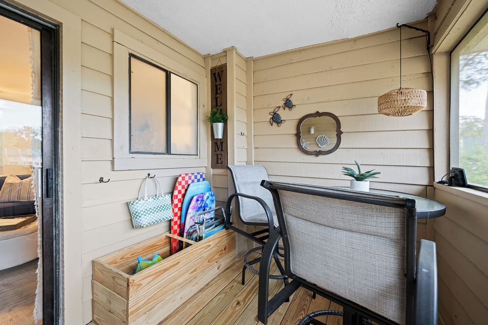 Your private screened porch offers a seamless extension of the living space, overlooking the tennis courts. With cozy seating, a table for two, and sand toys available for guests, it’s designed for both relaxation and fun.