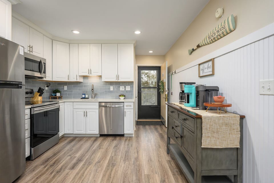 Open front door featuring a storm door into the open concept kitchen. 