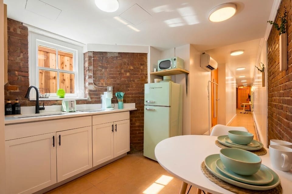 Fully equipped kitchen with modern appliances, including a coffee maker, toaster, kitchenette,  plus a small dining table