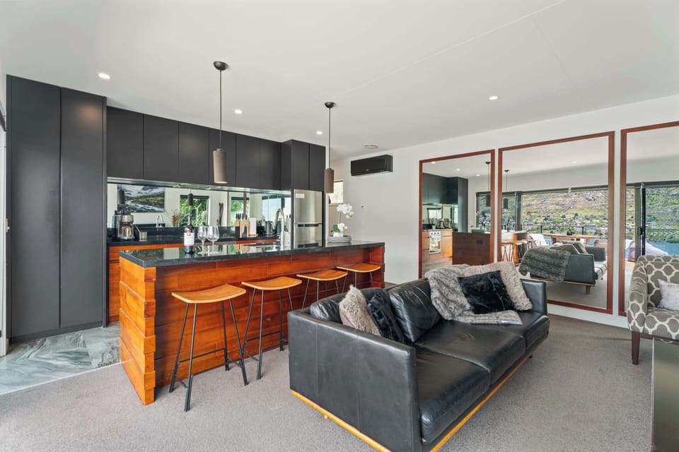 Gorgeous kitchen and living area featuring full-length mirrors that reflect the stunning views, enhancing the sense of space and light.
