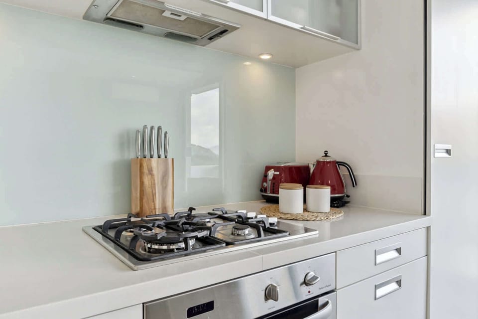 Fully Equipped Kitchen – Sleek kitchen with oven, stovetop, microwave, and modern appliances.