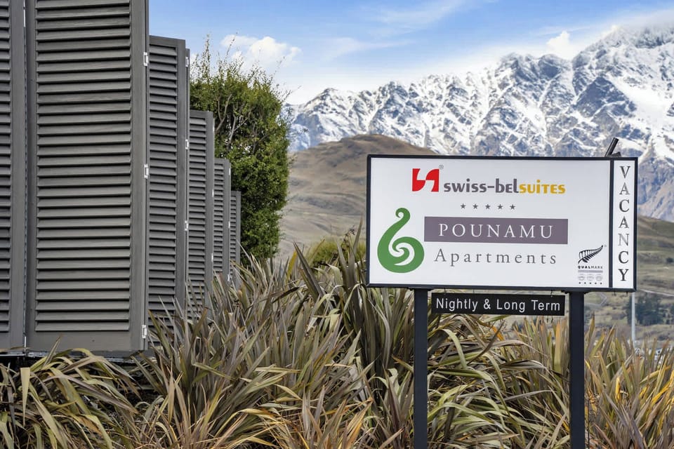 Pounamu Apartments entry with alpine backdrop.