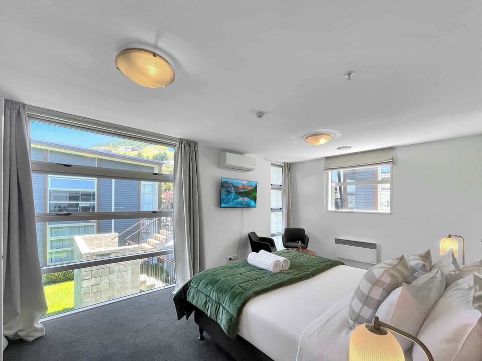 Sunny studio with seating area, Smart TV, and garden outlook.