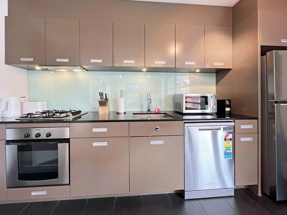 Sleek, modern kitchen fully equipped with quality appliances — perfect for easy meals at home or entertaining during your stay.