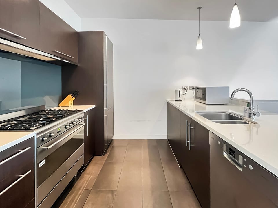 Modern kitchen with full appliances and generous bench space for easy meals at home