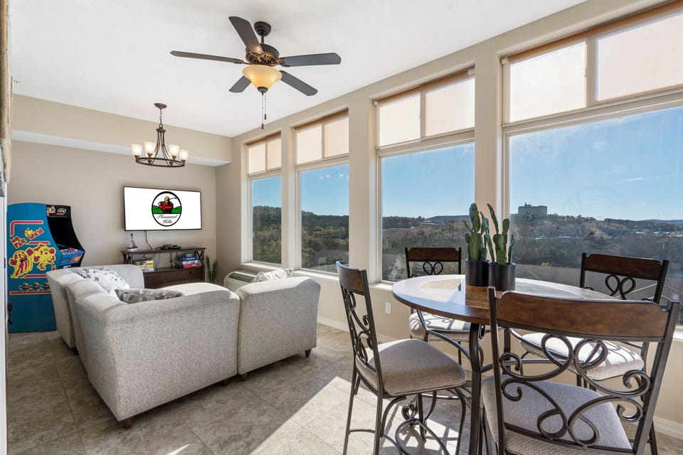 Sunroom with a Comfortable Sectional, Cable TV, Arcade Game, and Extra Dining Space