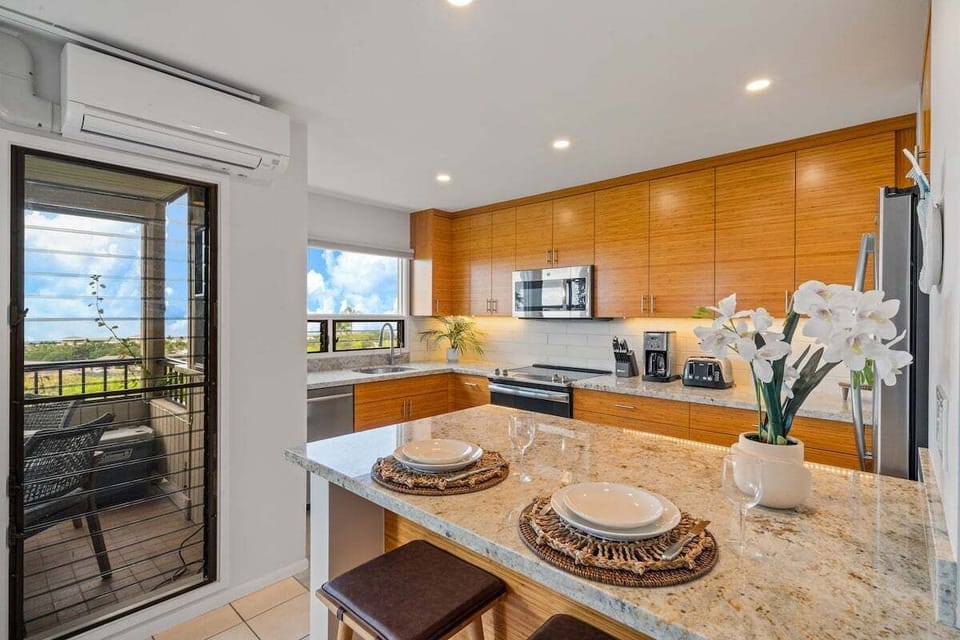 Kitchens brighten with wood and steel, islands and flowers tying function to style.