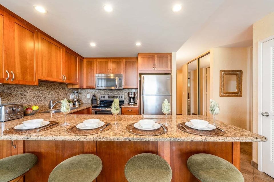Cook in granite kitchens warmed by wood, steel, and island air.