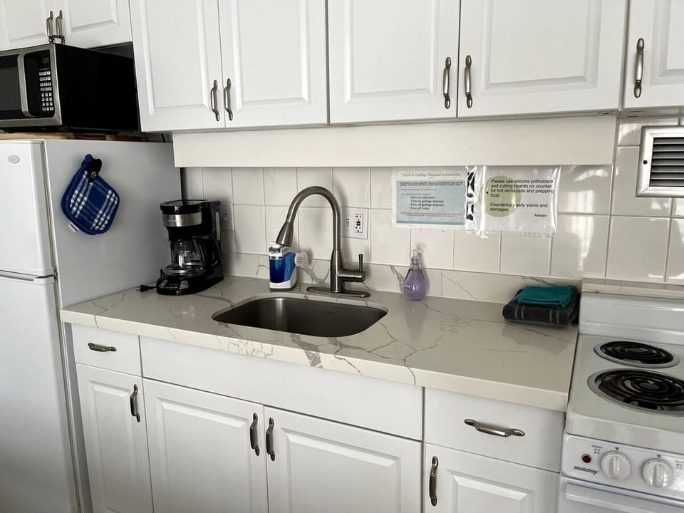 Full kitchen with fridge, stove, microwave and all essentials for cooking.