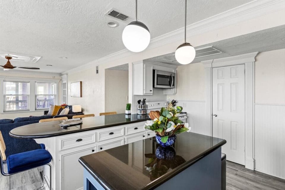 This inviting kitchen features a spacious island and a cozy seating area, perfect for entertaining or enjoying casual meals with family and friends while taking in the coastal vibe.