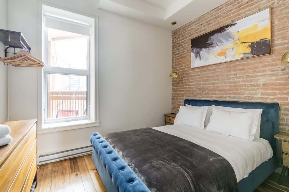 Airy and bright bedroom featuring a stylish mix of white and brick walls, creating a perfect blend of modern and rustic comfort.