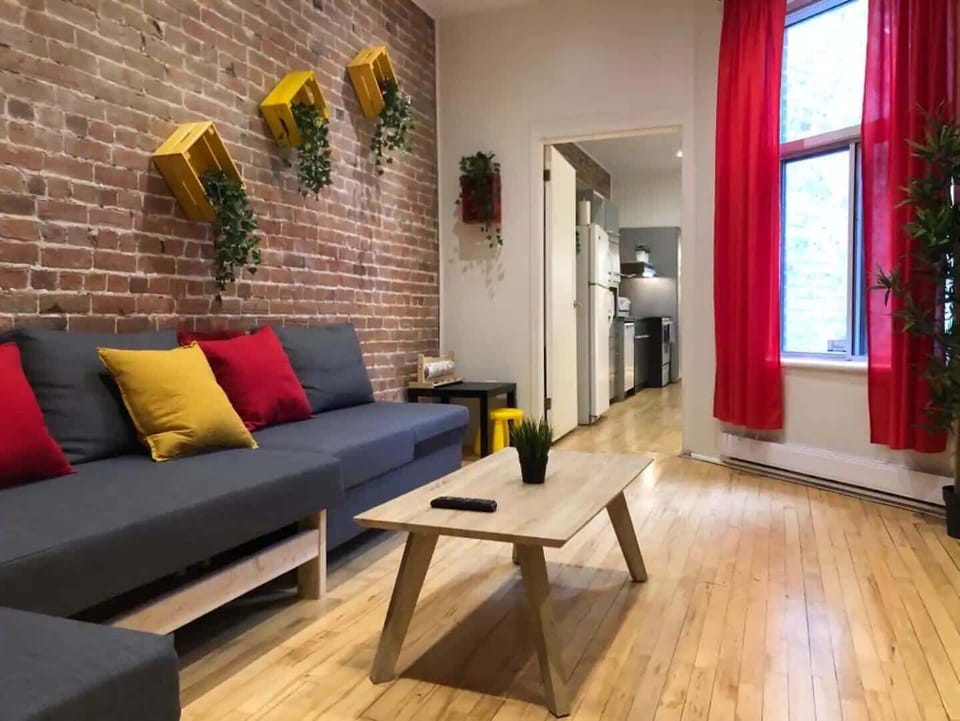 Spacious living area featuring a classic exposed brick wall