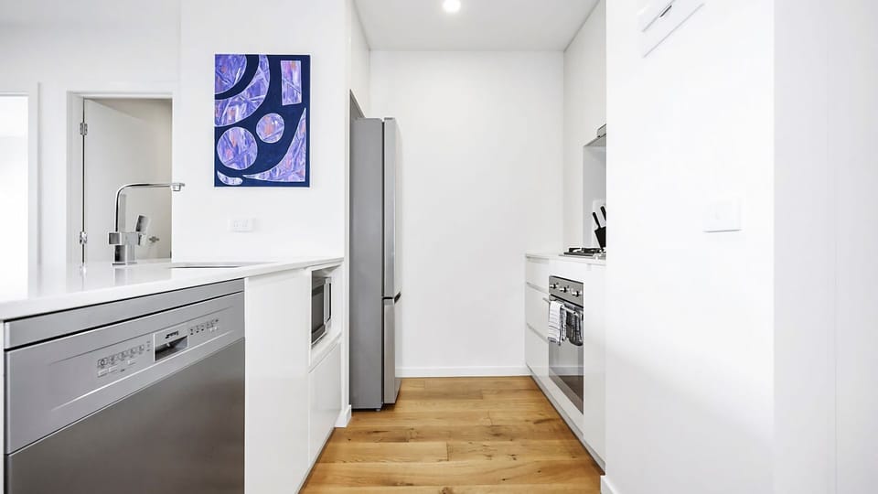 Contemporary kitchen with clean white cabinetry and premium appliances.