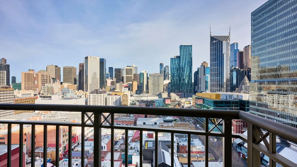 Private balcony offering sweeping views across the vibrant city skyline.