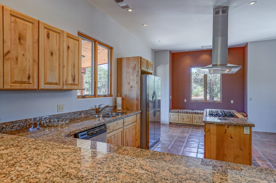 The open-concept chef's kitchen is a culinary dream with granite countertops, stainless steel appliances, ample prep space and gorgeous cabinetry.